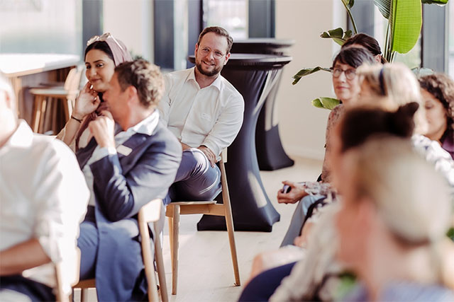 Man in office with proud team [Adobe Stock - Jordi P DE/peopleimages.com]